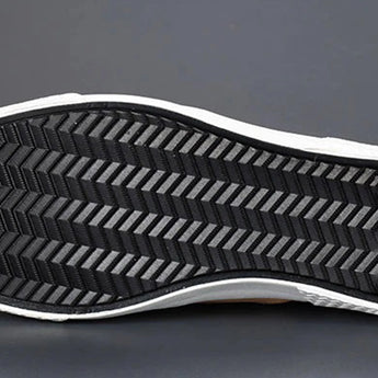 Men's grey slip-on sneakers with red accents, featuring synthetic rubber soles, designed for style and comfort in walking and outdoor activities.
