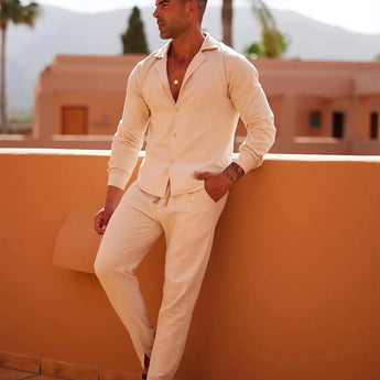 Men wearing lightweight beige linen pants, styled for summer fashion and resort wear. The outfit includes a dress shirt and eyewear, with a focus on casual, comfortable elegance.