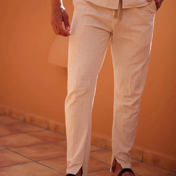 Men's lightweight beige linen pants designed for summer fashion and resort wear, highlighting the waist and thigh areas with a focus on the comfortable fit.
