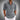 Men's lightweight blue linen shirt in a casual summer button-up style, featuring a classic collar and long sleeves, displayed on a model with a focus on the upper body. The shirt appears to have subtle grey tones, suitable for a relaxed yet polished look.