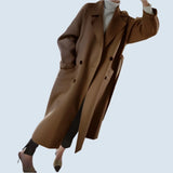 Men's luxury camel wool double-breasted overcoat, tailored fit, shown over dress shirt and tie.