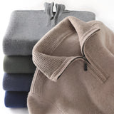 Men's luxury half-zip cashmere sweater in a soft grey color, featuring a high collar and long sleeves, made from premium knitwear fabric.