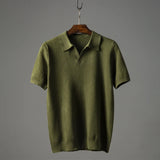 Men's luxury knit polo shirt in green, featuring a sleek design with a stylish collar and button-down front, displayed on a clothes hanger.