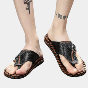 Men's black luxury leather braided flip flops, stylish beach sandals shown on foot.