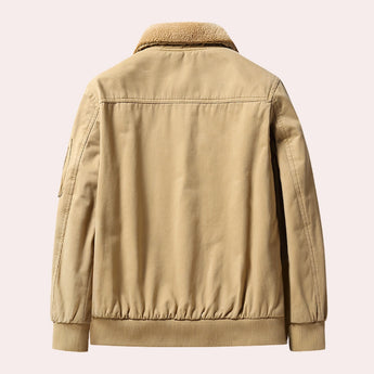 Men's tan shearling bomber jacket with a warm, plush collar and sleeves, featuring a button front closure, showcasing a luxurious and stylish design for winter.