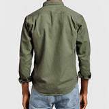Men's military green canvas shirt featuring a sturdy collar and long sleeves, designed for durability in outdoor work environments.