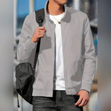 A man wearing a minimalist gray bomber jacket in size 2XL, featuring sleek and versatile design suitable for various occasions. The jacket is styled over a dress shirt, with visible details of the neckline and sleeves, showcasing a modern and fashionable look.