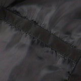Men's minimalist black bomber jacket with long sleeves displayed on a wooden surface. The jacket is sleek and versatile, ideal for various styles and occasions.
