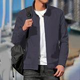 Men's blue bomber jacket in 2XL size, featuring a minimalist design with a clean silhouette. The jacket has a sleek finish and versatile style, suitable for casual wear. The model is standing, showcasing the jacket's well-fitted shoulders and sleeves.