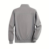 Men's minimalist black bomber jacket with a sleek design, featuring a high collar and long sleeves, displayed on a neutral grey background.