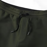 Light grey men's moisture-wicking quick-dry athletic t-shirt worn by a person with glasses, visible sleeves, and outdoor shoes.
