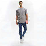 Men's light grey moisture-wicking quick-dry athletic T-shirt being worn, showing the leg, neck, waist, sleeve, and knee in a sporty gesture.
