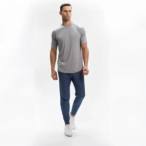 Men's light grey moisture-wicking quick-dry athletic T-shirt being worn, showing the leg, neck, waist, sleeve, and knee in a sporty gesture.