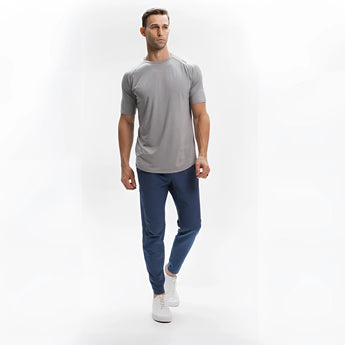 Men's light grey moisture-wicking quick-dry athletic T-shirt being worn, showing the leg, neck, waist, sleeve, and knee in a sporty gesture.