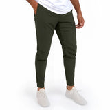A man wearing a light grey moisture-wicking quick-dry athletic t-shirt and hunter green jeans, showcasing the fit and flexibility of the shirt with his arms slightly bent and legs apart.