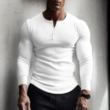 Men's muscle-fit grey Henley shirt in a slim-fit design, worn casually by a bearded man in a white and black outfit, highlighting the shirt's muscle-enhancing fit and thermal properties.