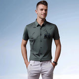 Men's olive green polo shirt in a 4XL size, featuring a nautical teal embroidery design. The shirt is displayed on a mannequin or model, highlighting its stylish summer appeal with short sleeves and a classic collar.