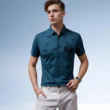 Men's teal embroidered polo shirt being worn by a person standing with sunglasses, showcasing short sleeves and a stylish summer design.