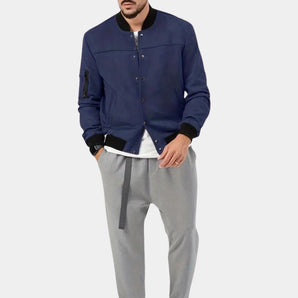 Men's navy blue lightweight bomber jacket featuring a utility pocket, with a collar and ribbed sleeves and waist, shown on a mannequin wearing a grey jersey underneath.