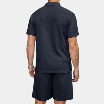 Men's navy blue polo shirt paired with matching active shorts, displayed as a casual and breathable summer outfit.