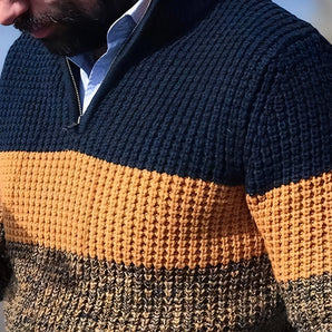 Men's navy and mustard chunky knit high-collar sweater with long sleeves, featuring a textured design.