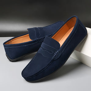 Men's navy suede penny loafers in dark blue, featuring a luxury slip-on design with a synthetic rubber sole for comfort.