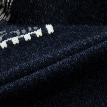 Men's dark blue wool sweater with a snowflake pattern and a turtleneck design, featuring long sleeves.