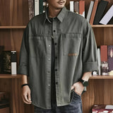 Olive green men's utility shirt in cotton with an oversized, casual long sleeve design, featuring a collar and button-down front.