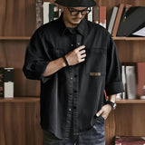 Men's oversized olive green cotton utility shirt with long sleeves, featuring a casual design.