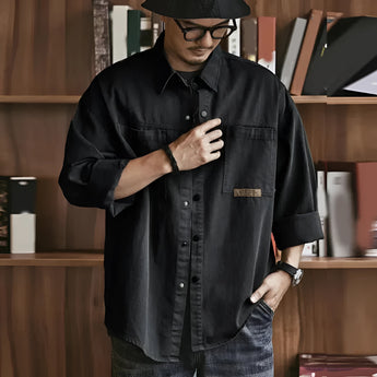 Men's oversized olive green cotton utility shirt with long sleeves, featuring a casual design.