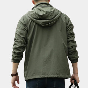 Men's olive green hooded cargo jacket featuring a lightweight urban windbreaker design with a structured collar, long sleeves, and practical shoulder detailing.