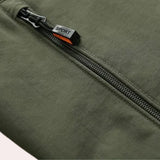 Men's olive green hooded cargo jacket with spacious front pockets, featuring long sleeves and a lightweight design ideal for urban wear. The jacket includes a windbreaker feature and a khaki-toned hue.