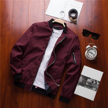 Men's olive green lightweight bomber jacket with a front zipper pocket, featuring long sleeves and a ribbed collar.
