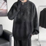 Men's oversized black chunky knit woolen crewneck sweater featuring long sleeves and ribbed collar, suitable for a casual or layered look.