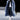 Men's oversized blue faux fur longline coat with a luxurious urban design, featuring a wide collar and long sleeves, styled for winter wear. The coat extends to the knees, offering a fashionable and warm outerwear option.