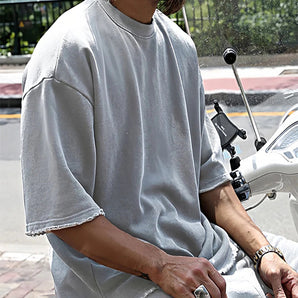 Men's oversized white t-shirt with loose fit, featuring casual urban fashion style, displayed on a model.