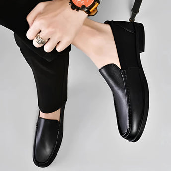Men's premium blue leather penny loafers displayed on a neutral background, showcasing their sleek slip-on design and luxurious craftsmanship.