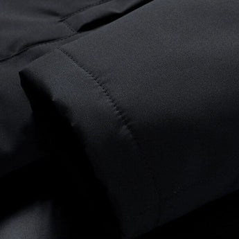 Men's reversible winter jacket with black and brown faux fur, featuring a hood and grey accents, displayed in an automotive setting.