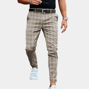 Men's slim fit beige plaid trousers in a casual and tapered style, shown with a persimmon color scheme in size 3XL. The focus is on the plaid pattern and tailored fit, paired with a white dress shirt and casual footwear.