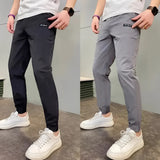 Men's slim fit black cargo pants with a tapered leg, styled with a casual outfit featuring a white shirt and blue sneakers, showcasing versatility and modern fashion.