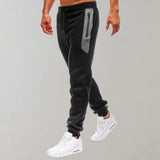Men's slim fit black joggers with zipper pockets, suitable for gym and casual wear, featuring a comfortable leg fit and sitting at the waist.