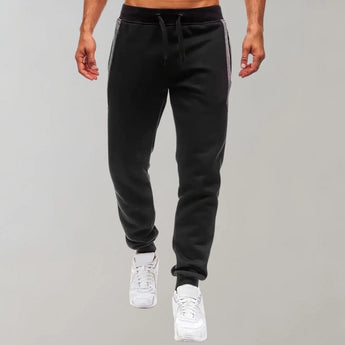 Men's slim fit black joggers with zipper pockets, designed for gym and casual wear, displayed on a model.