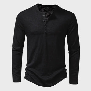 Men's slim fit black long sleeve Henley shirt made from a cotton blend, featuring a buttoned placket and a relaxed collar.