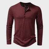 Men's slim fit black long sleeve Henley shirt made of cotton blend fabric, featuring a buttoned collar detail.