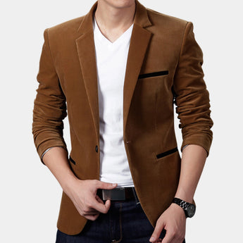 Men's slim fit brown corduroy blazer worn over a black dress shirt and paired with jeans, showcasing a casual business fashion look. The model is wearing a watch on their wrist, emphasizing a stylish and fashionable appearance.