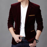 Men's slim fit brown corduroy blazer paired with a white dress shirt, showcasing a casual business fashion style. The blazer has a well-defined collar and sleeves, with a focus on tailoring around the waist. The outfit is completed with jeans and a watch, providing a modern, relaxed yet professional look.