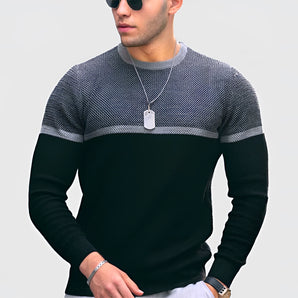 Men's black and white slim fit color block crew neck sweater, showing long sleeves and a casual design, modeled in a standing pose.