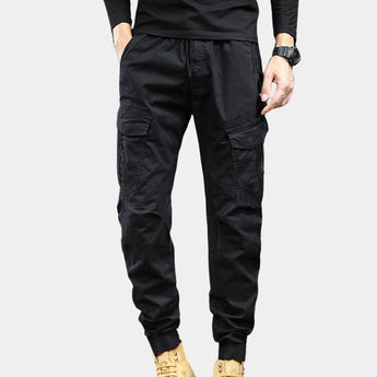 Men's slim fit black cargo pants featuring a multi-pocket design, tailored for a military-inspired look with a 33-inch waist, showcasing a fashionable and functional style.