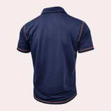 Men's slim-fit athletic polo shirt in navy blue with contrast piping, featuring a collar and short sleeves, designed for sportswear.