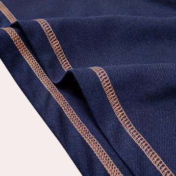 Men's slim-fit navy blue athletic polo shirt featuring contrast piping, short sleeves, and a classic collar design.